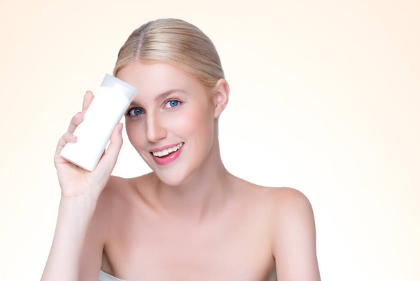Personable beautiful perfect natural skin woman hold mockup tube moisturizer cream for skincare treatment product advertisement in isolated background with expressive facial and gesture expression. - 写真・画像