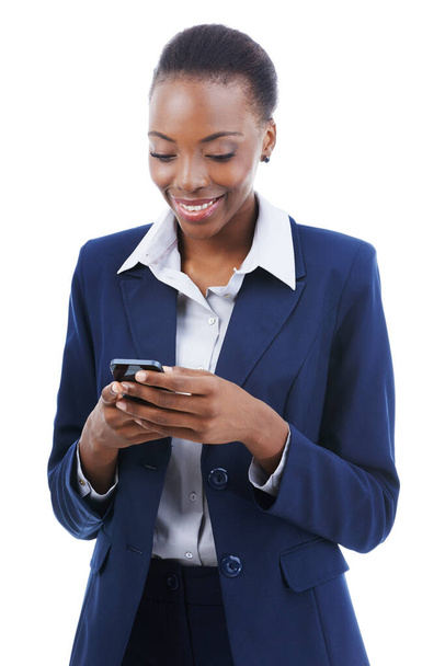 Working on the move. Studio shot of a young african american businesswoman texting on a mobile isoalted on white - Foto, Imagen