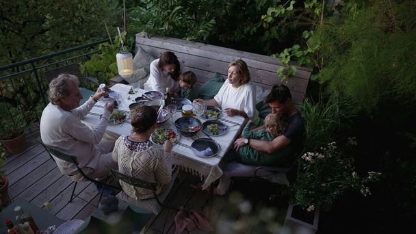 Amici e famiglia mangiare cibo insieme a casa patio cortile - Foto, immagini