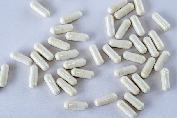 Ein Stapel weißer Medikamente oder Nahrungsergänzungsmittel auf beigem Hintergrund. Ansicht von oben, Nahaufnahme - Foto, Bild