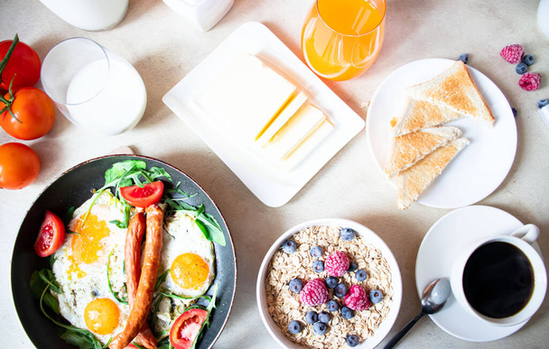 Breakfast. Fried eggs, oatmeal, coffee, berries. Morning. - Foto, Imagen