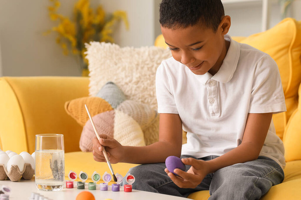 Piccolo ragazzo afro-americano pittura uovo di Pasqua a casa - Foto, immagini
