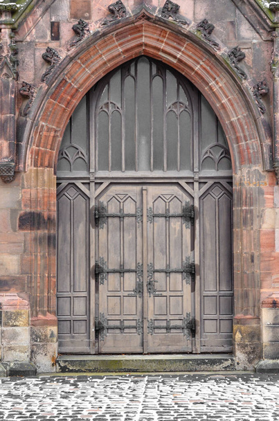 Widok na stary gotycki budynek z drewnianymi drzwiami - Zdjęcie, obraz