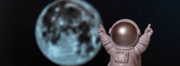 Πλαστικό παιχνίδι αστροναύτης στο φεγγάρι φόντο Αντιγραφή χώρου. Έννοια της εκτός γης ταξίδια, ιδιωτικές διαστημικές εμπορικές πτήσεις. Διαστημικές αποστολές και βιωσιμότητα - Φωτογραφία, εικόνα