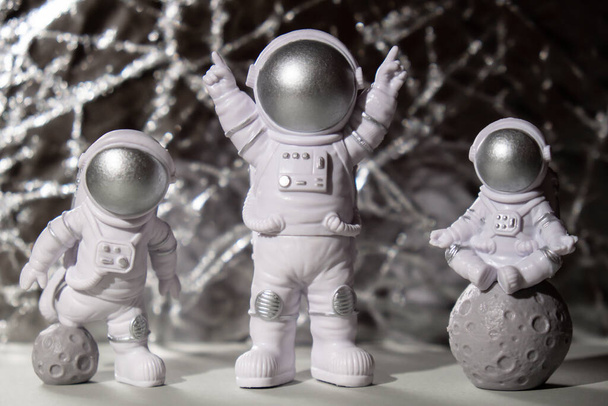 Three Plastic toys figure astronaut on silver background Copy space. Concept of out of earth travel, private spaceman commercial flights. Space missions and Sustainability - Foto, afbeelding
