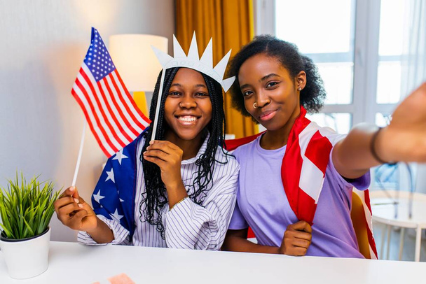 two happy african american sister celebrating usa independence day at home in cozy apartment. - Valokuva, kuva