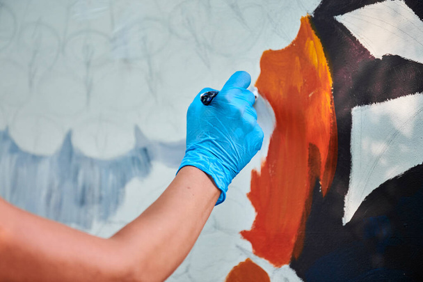 Рука художника-жінки тримає пензлик і малює абстрактне сюрреалістичне зображення на білому полотні на фестивалі живопису на відкритому повітрі, живописі художній процес. Жінка художник малює атмосферну сюрреалістичну картину
 - Фото, зображення