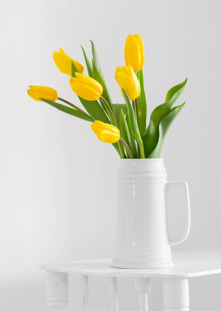 yellow tulips in vase on white background - Photo, image