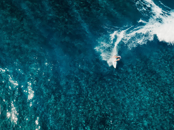 Aerial view with surfing on wave. Perfect waves with surfers in clear ocean - Zdjęcie, obraz