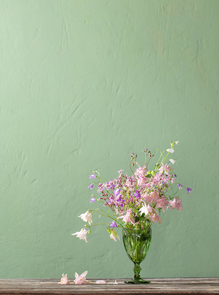 wild flowers in green  bocal  on background green wall - Fotografie, Obrázek