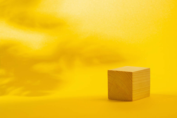 wooden podium cube on bright yellow background - Photo, image