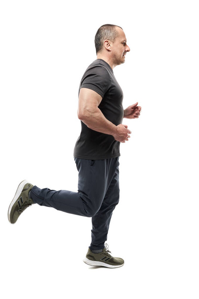 Mature athletic man running isolated on white background - Valokuva, kuva