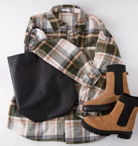 Black eco shopping bag with place for text. Bag mock up template top view. Wardrobe with shirt and boots. Clothes and accessories. Set modern look accessories. Unisex plaid shirt - 写真・画像
