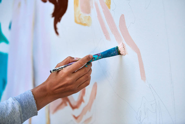 Main d'artiste tient un pinceau et dessine image abstraite surréaliste sur toile blanche au festival de peinture d'art en plein air, peinture processus d'image d'art. Artiste peint tableau atmosphérique - Photo, image
