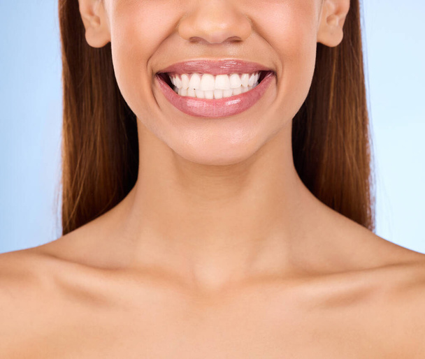 Dental, teeth and smile of woman in studio for beauty, cleaning and self care. Oral hygiene, natural and cosmetic treatment with girl model isolated on blue background for veneers, fresh or results. - Фото, зображення