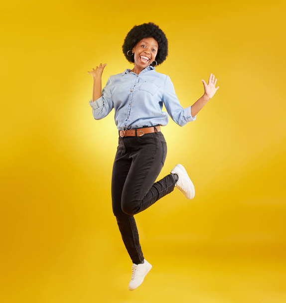 Jump, excited and portrait of black woman on yellow background with energy, happiness and smile in studio. Winner mockup, celebration and isolated happy girl jumping for freedom, winning and success. - Фото, изображение