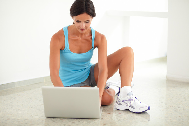 Sporty hispanic female working on her laptop - Zdjęcie, obraz