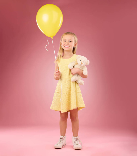 Teddy bear, girl balloon and portrait with a soft toy with happiness and love for celebration in studio. Isolated, pink background and a young female feeling happy, joy and cheerful with friend. - Foto, imagen