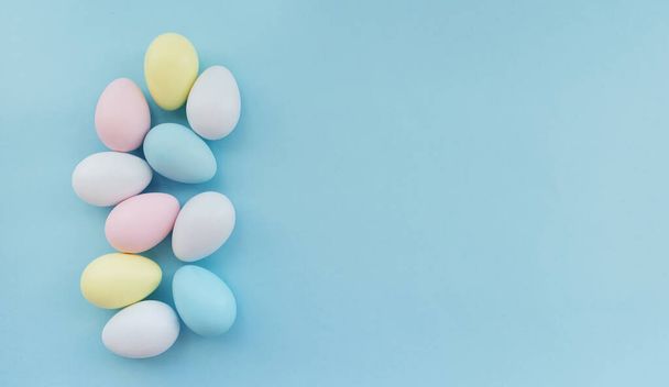Colorful Easter eggs on a pastel blue background. Easter is coming concept. Easter card, creative idea. View from above. Minimal style. High quality photo. - Фото, изображение