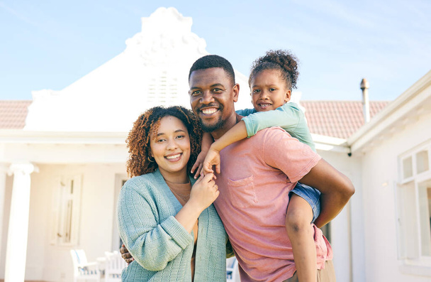 Black family, portrait smile and hug for real estate, new home or property together in the outdoors. Happy mother and father with daughter on piggyback smiling for mortgage, house loan or investment. - Foto, Imagem