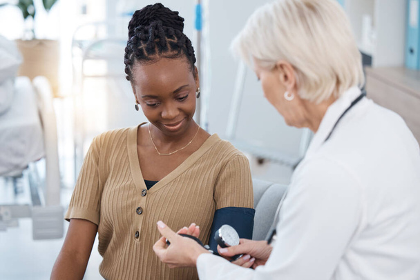 Blood pressure, hypertension and doctor with black woman in hospital of healthcare, consulting and clinic services. Medical worker check patient arm pulse, test and heart wellness of diabetes results. - Foto, Imagen