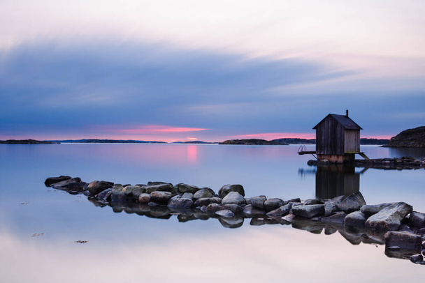 Zachód słońca nad budynkiem i jeziorem. Göteborg, Szwecja, Europa - Zdjęcie, obraz