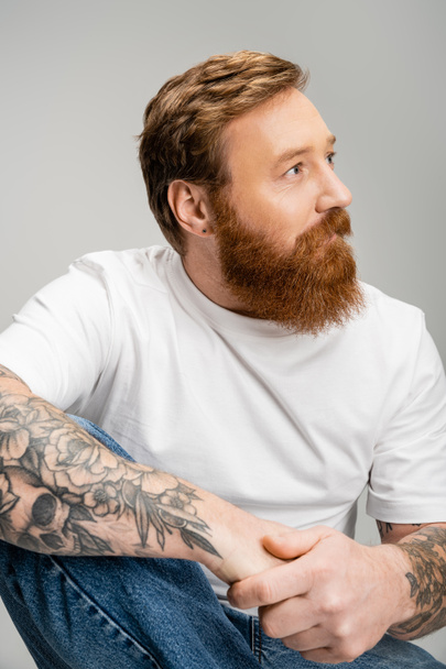 Bearded man in t-shirt and jeans looking away isolated on grey  - Фото, зображення