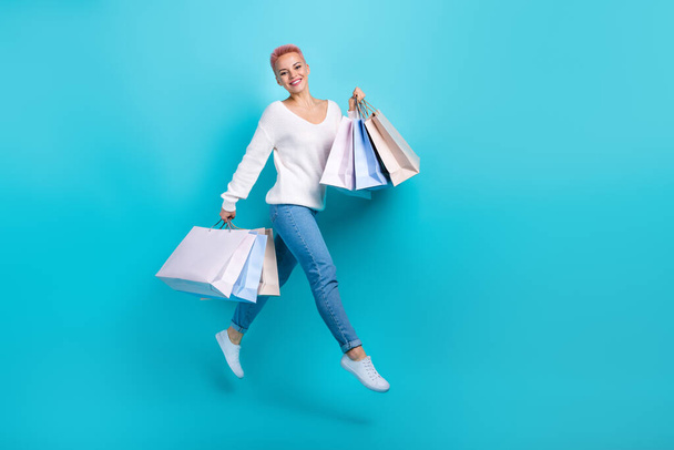 Full length size photo of jumping running youngster girl enjoy shopping hold much packages gifts day isolated on aquamarine color background. - Foto, imagen
