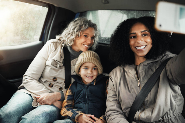 Selfie, hymy ja perheen road trip autossa liimaus, laatuaikaa ja pakopaikka yhdessä. Onnellinen, matkustaminen ja äiti, isoäiti ja lapsi, joka ottaa kuvan lomalle sosiaaliseen mediaan. - Valokuva, kuva