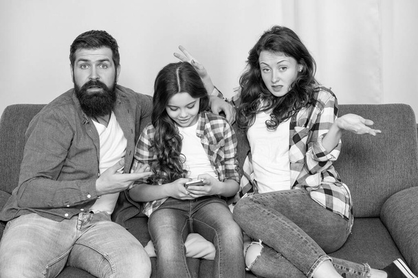 Unhappy parents complain on daughter spending much time on smartphone, child. - Fotografie, Obrázek