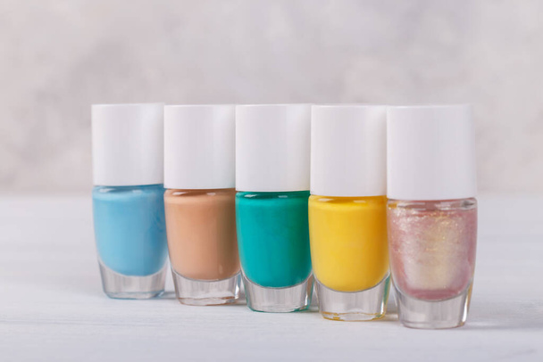 Nail polish five colourful bottles on grey background, copy space - Foto, Bild