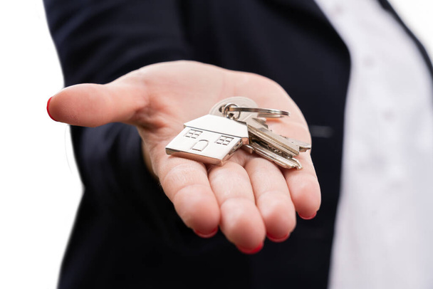 Close-up kluczy do domu w dłoni przez agenta nieruchomości sprzedaży kobieta hipoteka doradca izolowany na białym tle studio - Zdjęcie, obraz