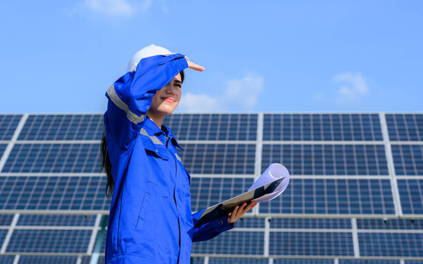 Engineer worker portrait with solar panel at solar farm, Solar farm with engineer workers analyzing solar cell, Renewable energy engineers work production of energy renewable or sustainable source - Foto, afbeelding