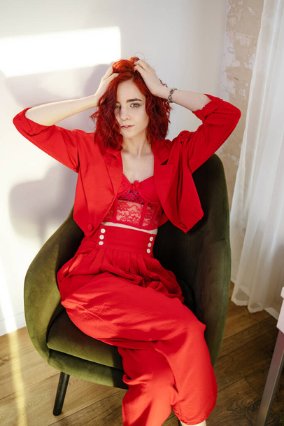 Mulher jovem na moda em um terno vermelho. Fundo vermelho. - Foto, Imagem