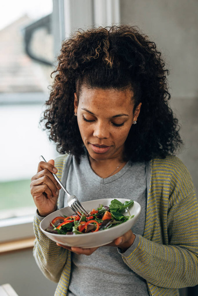 A mixed race woman eats salad - Fotó, kép