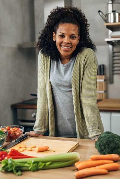 Beautiful mixed race woman is in the kitchen - Photo, Image