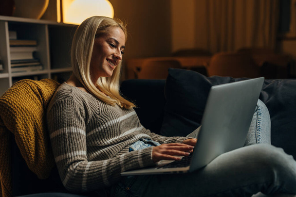 Happy caucasian woman works on computer at home - Photo, image