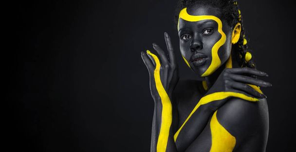 Le Visage d'Art. How To Make A Mixtape Cover Design - Télécharger Image haute résolution avec peinture corporelle noire et jaune sur femme africaine pour votre chanson musicale. Créer un modèle d'album avec une image créative - Photo, image