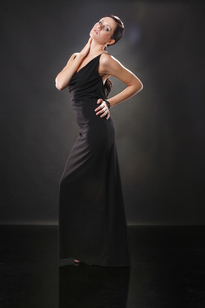 Elegant young woman in black dress - 写真・画像