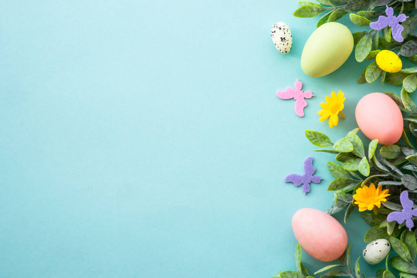 Spring or Easter background on blue. Eggs, spring leaves, flowers and colored butterflies. Flat lay with copy space. - Photo, Image
