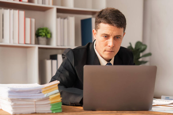 Portrait of businessman inside office with laptop, businessman in and business suit sitting working in the office. - Foto, imagen