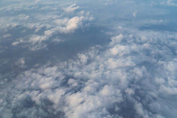 Bulutların üzerinde uçan uçak jeti seyahat ve ulaşım konseptinde pencereden mavi gökyüzü ile görünür. Doğa manzarası arka planı. - Fotoğraf, Görsel