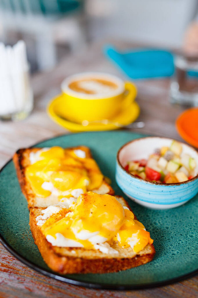 Delicious breakfast with eggs Benedict and juice - Foto, afbeelding