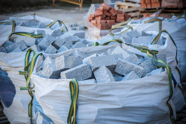 Raffia gran saco lleno de adoquines de granito. Concepto de material de construcción - Foto, imagen