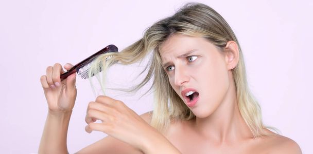 Alluring portrait of beauty cosmetic clean skin woman having brittle dry hair problem. Grimacing frustrated sad facial expression in pink isolated background. Damaged and hair loss concept. - Photo, Image