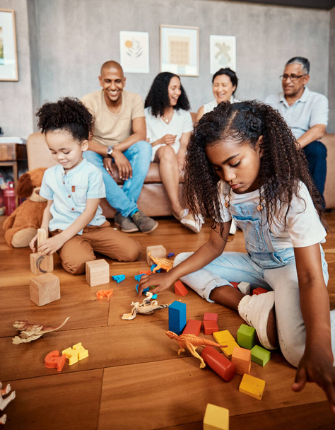 Family, happy and children playing with blocks for education, learning and curiosity. Living room, playful and kids with toys for mental development, childhood and hobby with parents and grandparents. - Photo, Image