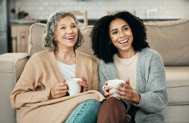 Love, mother and adult daughter on floor, coffee and quality time in living room, happiness and relax. Family, female child or mama with tea, smile or loving together in lounge, rest and conversation. - Photo, Image