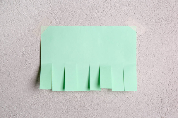 Blanco papier scheuren-off advertentie op lichte muur - Foto, afbeelding