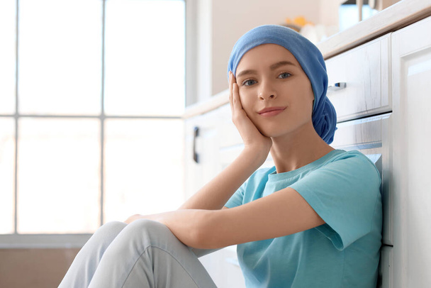 Teenage girl after chemotherapy sitting in kitchen - Zdjęcie, obraz