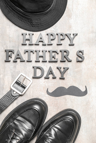Samenstelling met tekst HAPPY FATHER 'S DAY, mannelijke schoenen en accessoires op lichte achtergrond, close-up - Foto, afbeelding